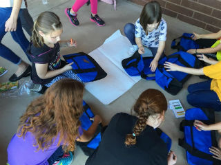 Student Lighthouse Team decorating and stuffing duffle bags for children in foster care so they can move with dignity