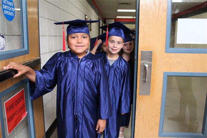  Kindergarten students wait in the hallway before graduation