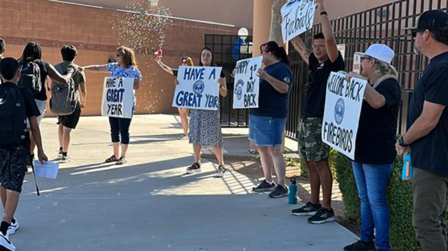 Community leaders and Willis Junior High staff greet students at the front gate