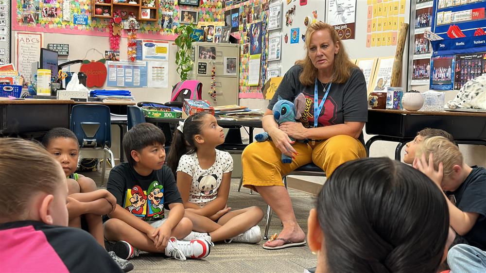 A teacher chats with her students in class