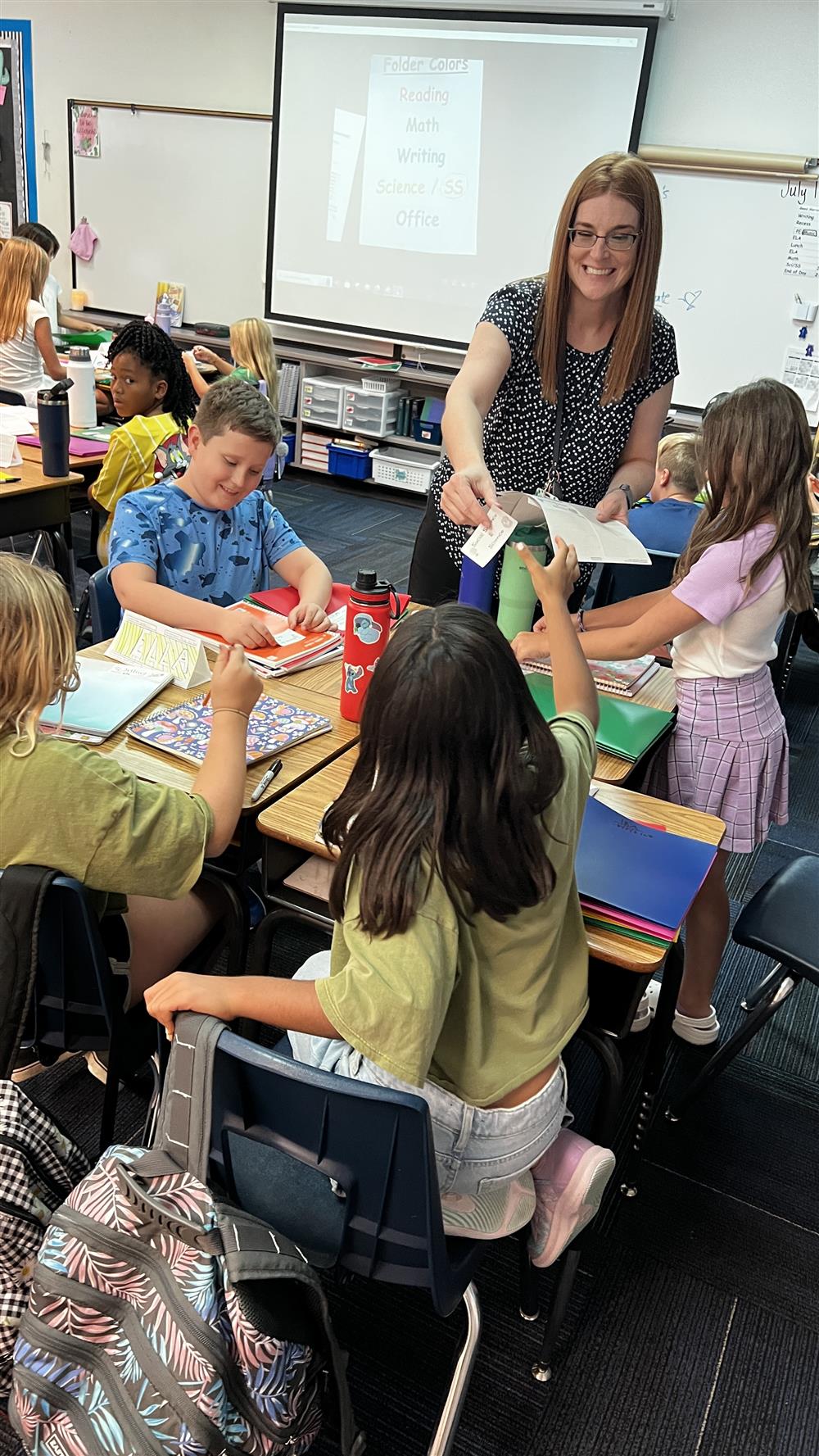 A teacher passes out papers to her students