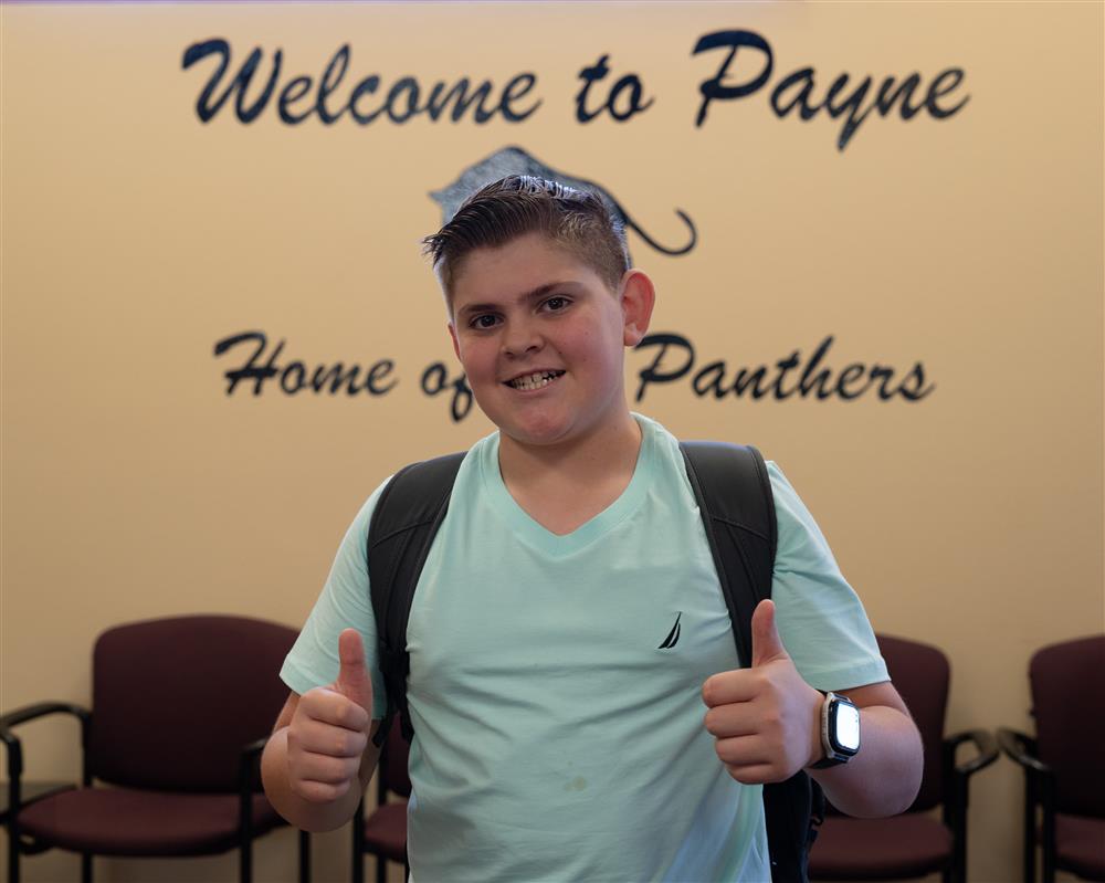 A student at Payne Junior High School gives a thumbs up to the camera