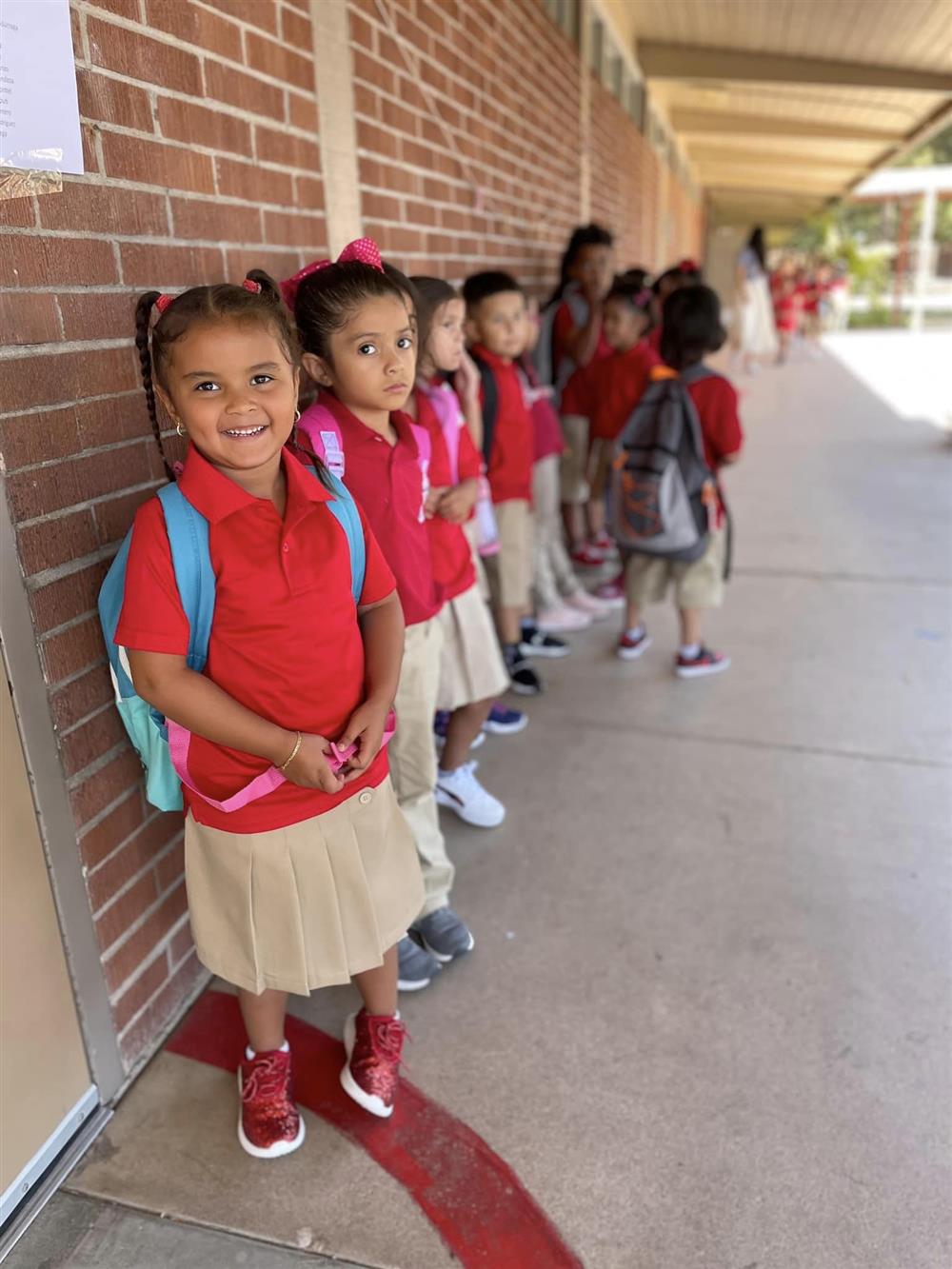 A student smiles while waiting to go into class at Galveston Elementary