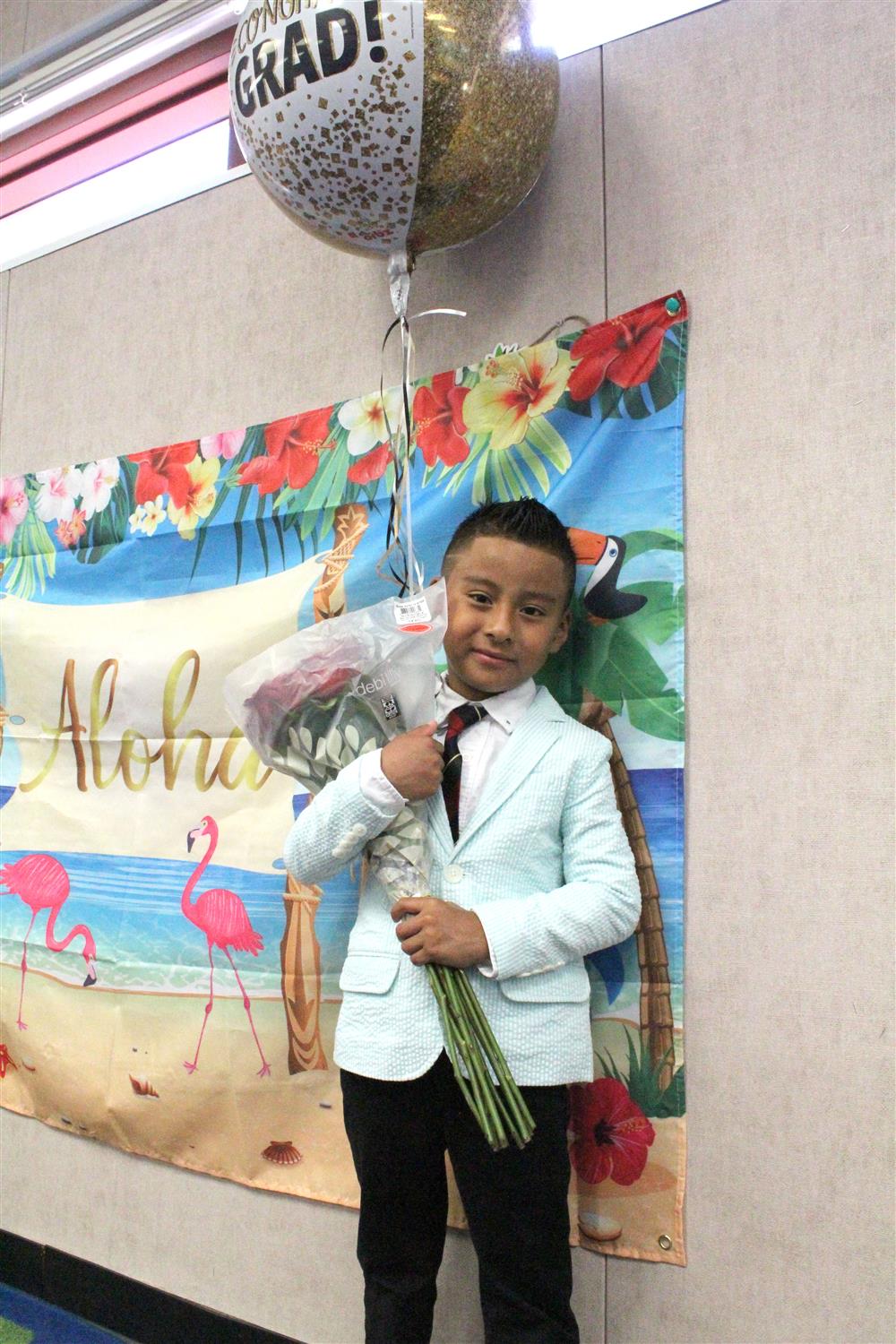 A student smiles with a graduation balloon and goodies