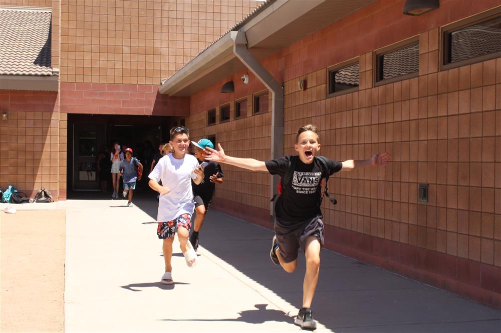 Students run out of the school and into the sunlight