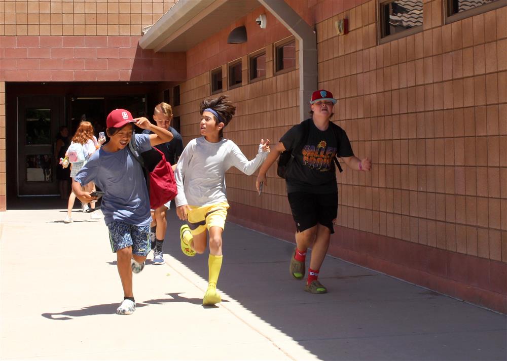 Students run out of the school and into the sunlight.