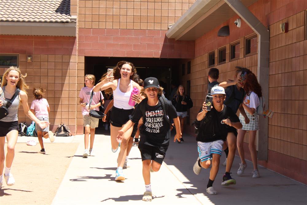 Students run out of the school and into the sunlight