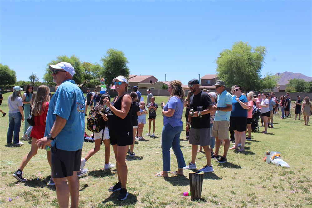 Students walk through a tunnel of parents with silly string