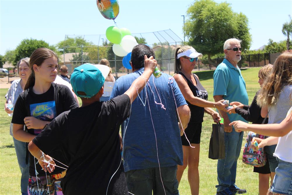 The back of a student using a silly string can on an adult family member